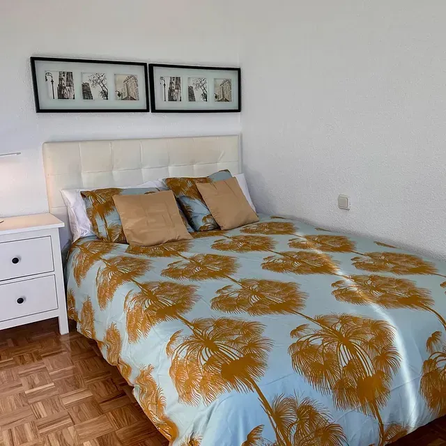 Un dormitorio con una cama y dos cuadros en la pared.