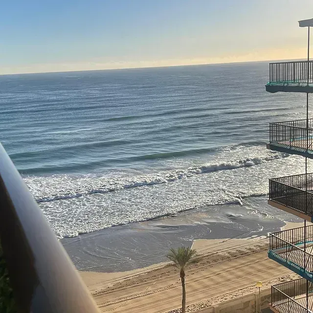 Una vista de una playa y el océano desde un balcón.