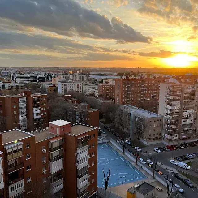 Una vista aérea de una ciudad con una puesta de sol al fondo.