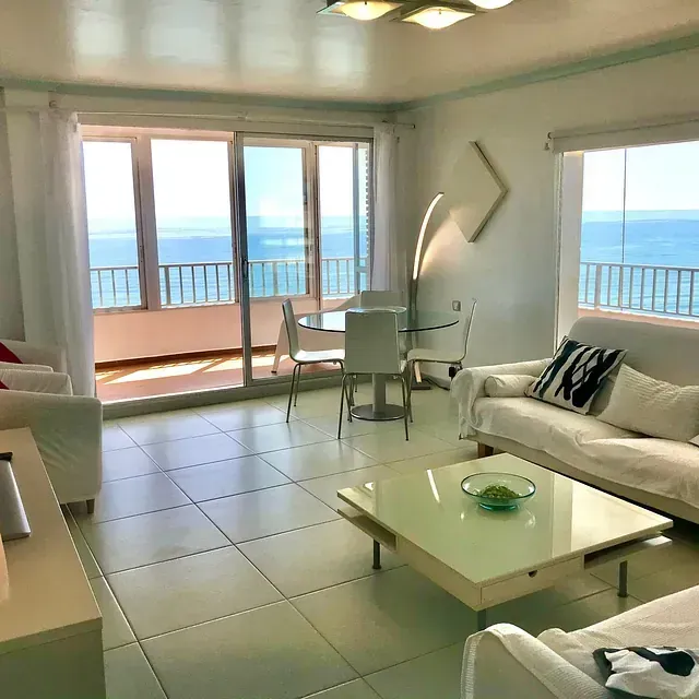 Una sala de estar con un sofá y una mesa con vista al mar.