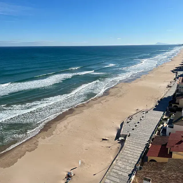 Una vista aérea de una playa con olas rompiendo en la orilla.