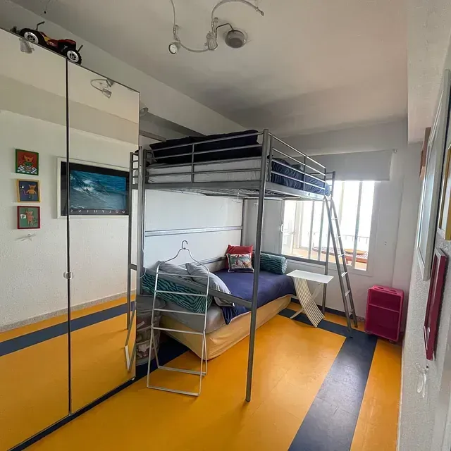 Un dormitorio con una litera y una escalera.