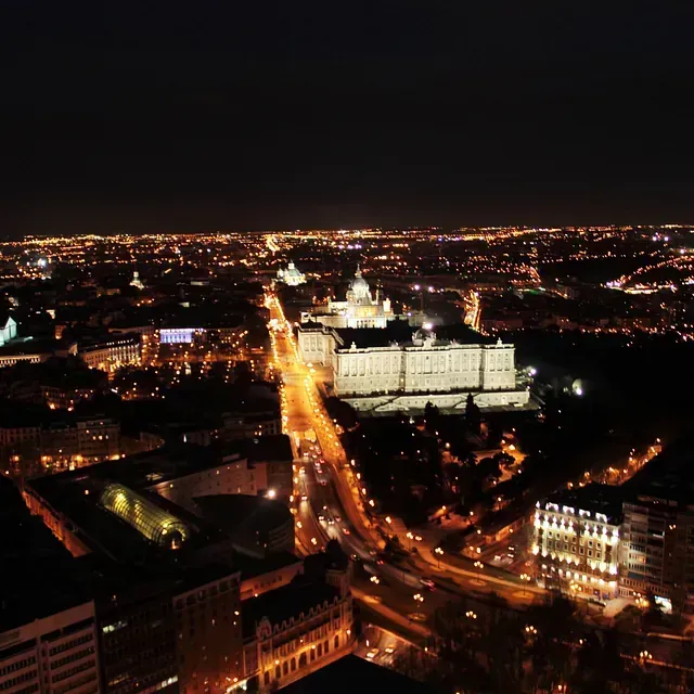Una vista aérea de una ciudad de noche con edificios iluminados.