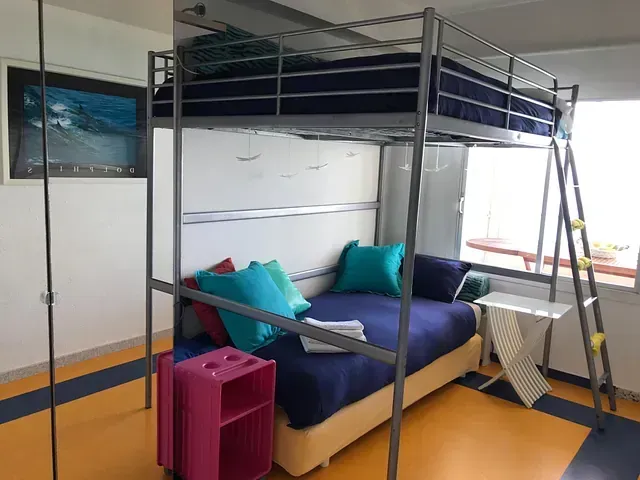 Un dormitorio con una litera y una escalera.