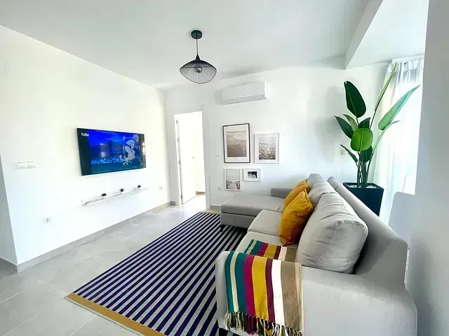 Una sala de estar con un sofá y un televisor en la pared.