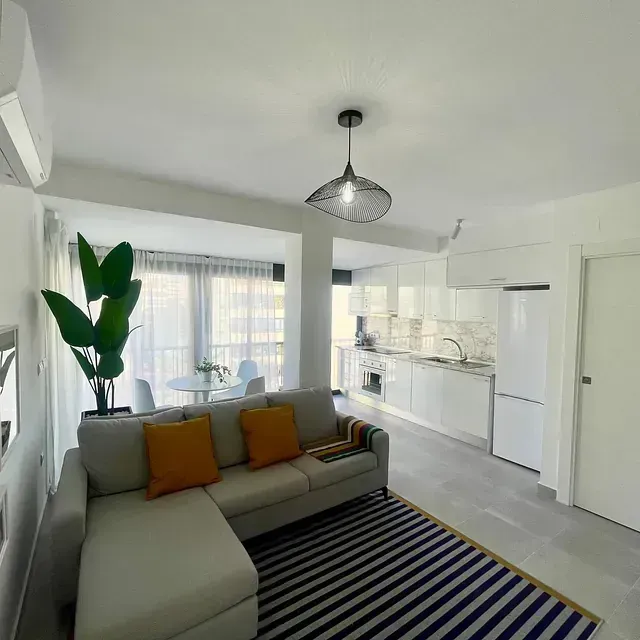 Una sala de estar con un sofá y una alfombra de rayas.