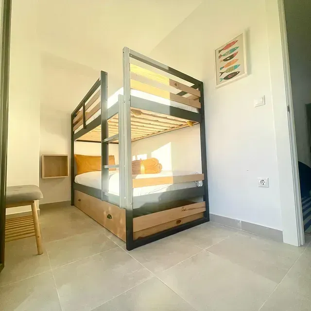 Un dormitorio con una litera y un cuadro de un pez en la pared.