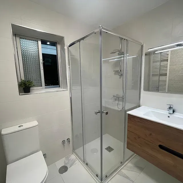 Un baño con inodoro, lavabo y ducha.