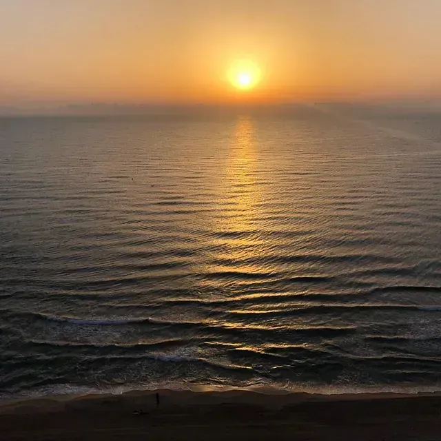 El sol se pone sobre el océano y se refleja en el agua.
