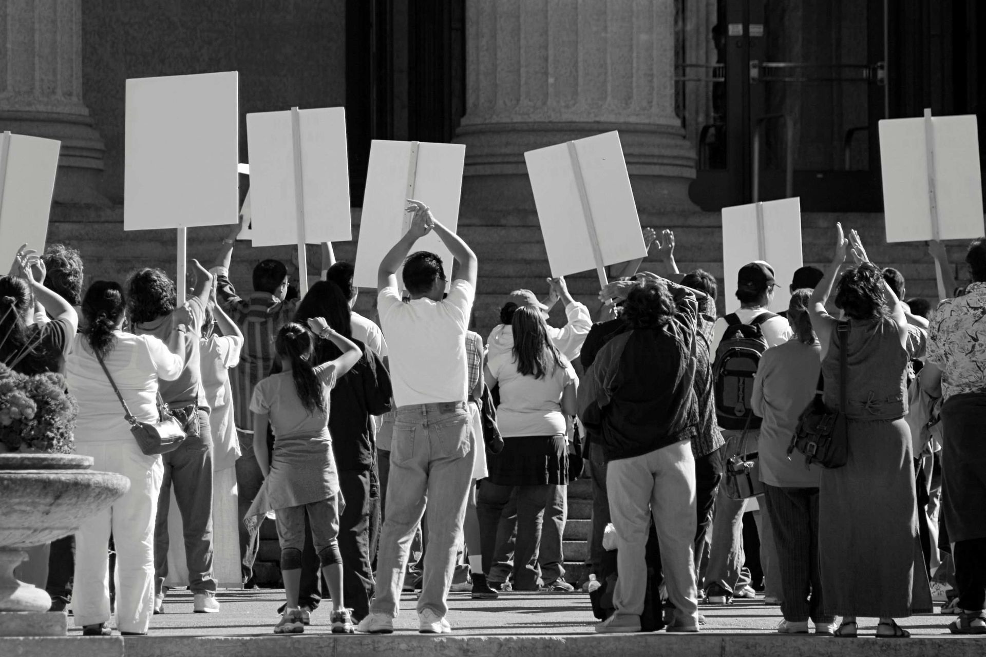 Un grupo de personas sosteniendo carteles frente a un edificio.