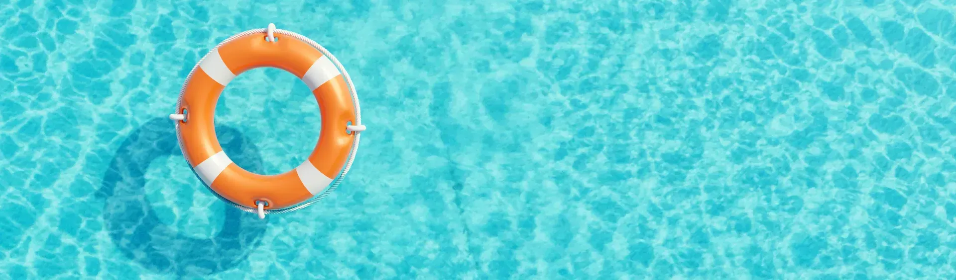 Un salvavidas naranja flota en una piscina.