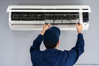 Sanitär-Heizungsbau Uhlenbroich Ein Mann repariert eine Klimaanlage