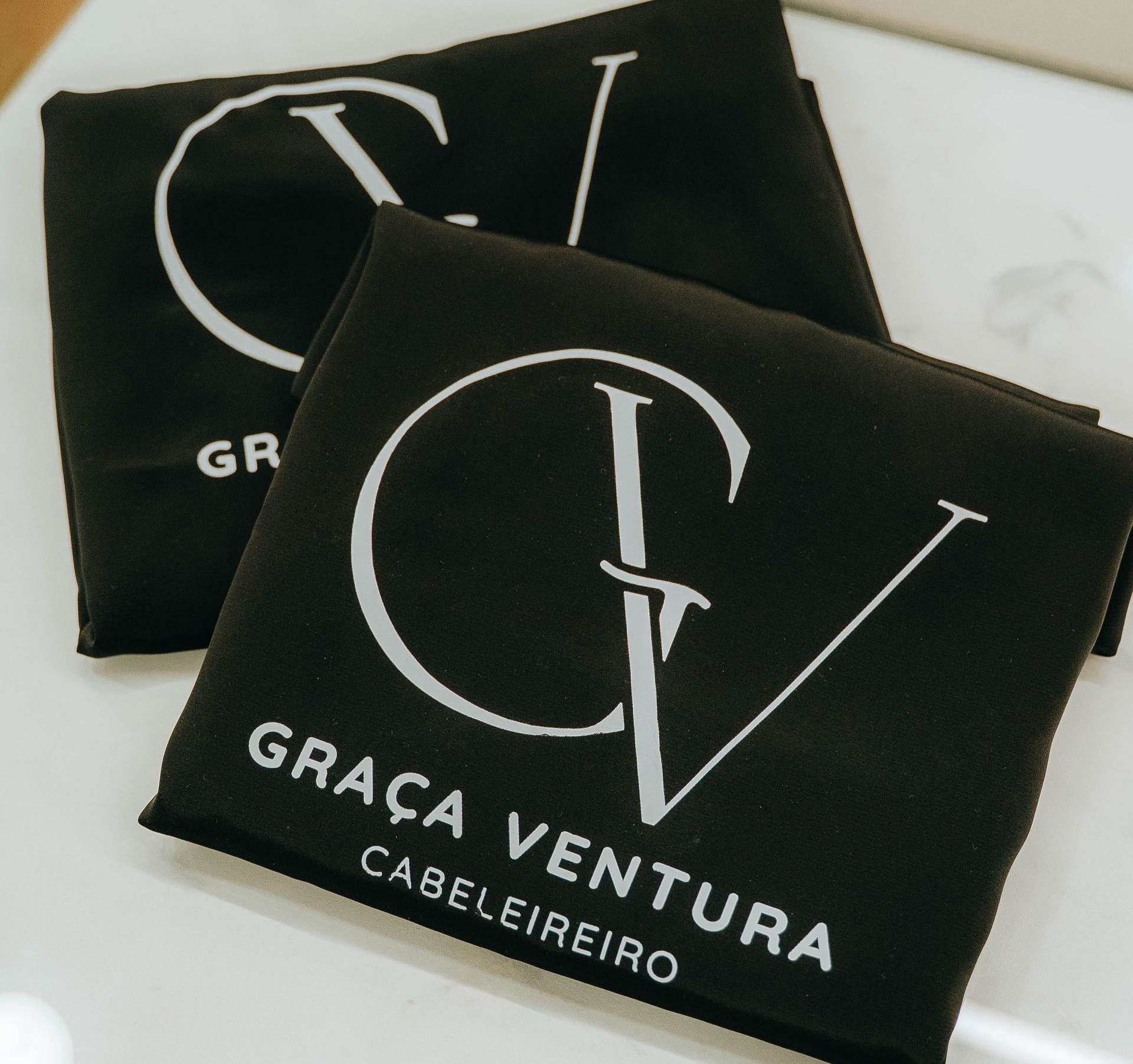 Duas sacolas pretas com o logotipo branco