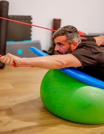 Un grupo de personas con mascarillas están haciendo ejercicios en un gimnasio.