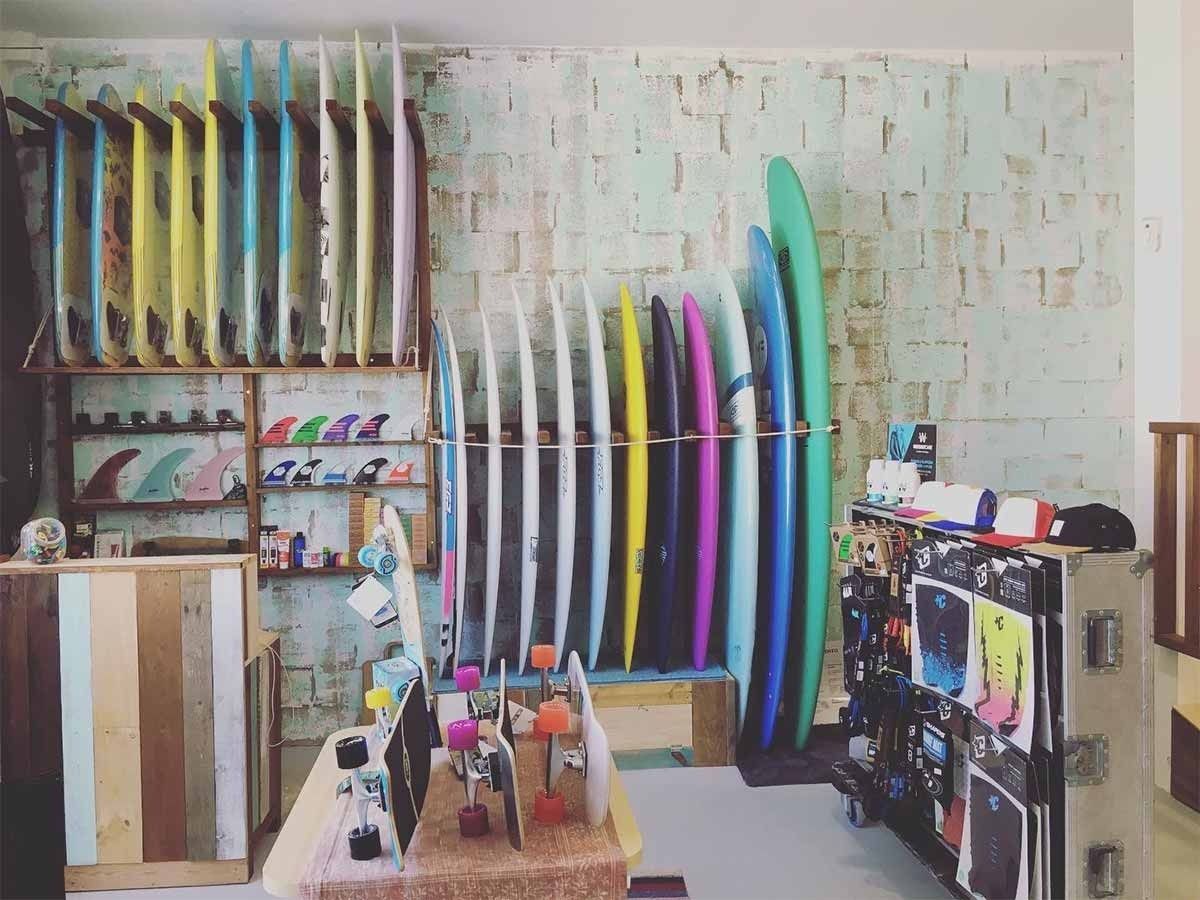 Una habitación llena de tablas de surf y patinetas.