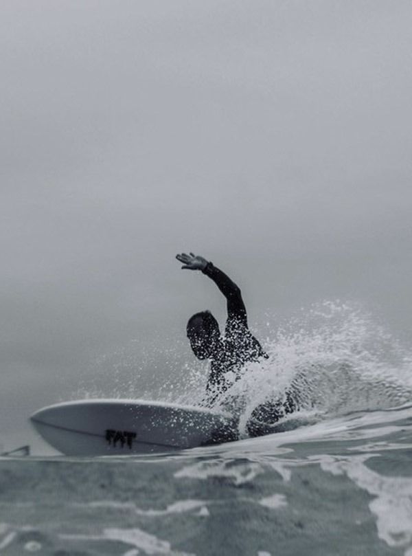 Un hombre está montando una ola en una tabla de surf en el océano.