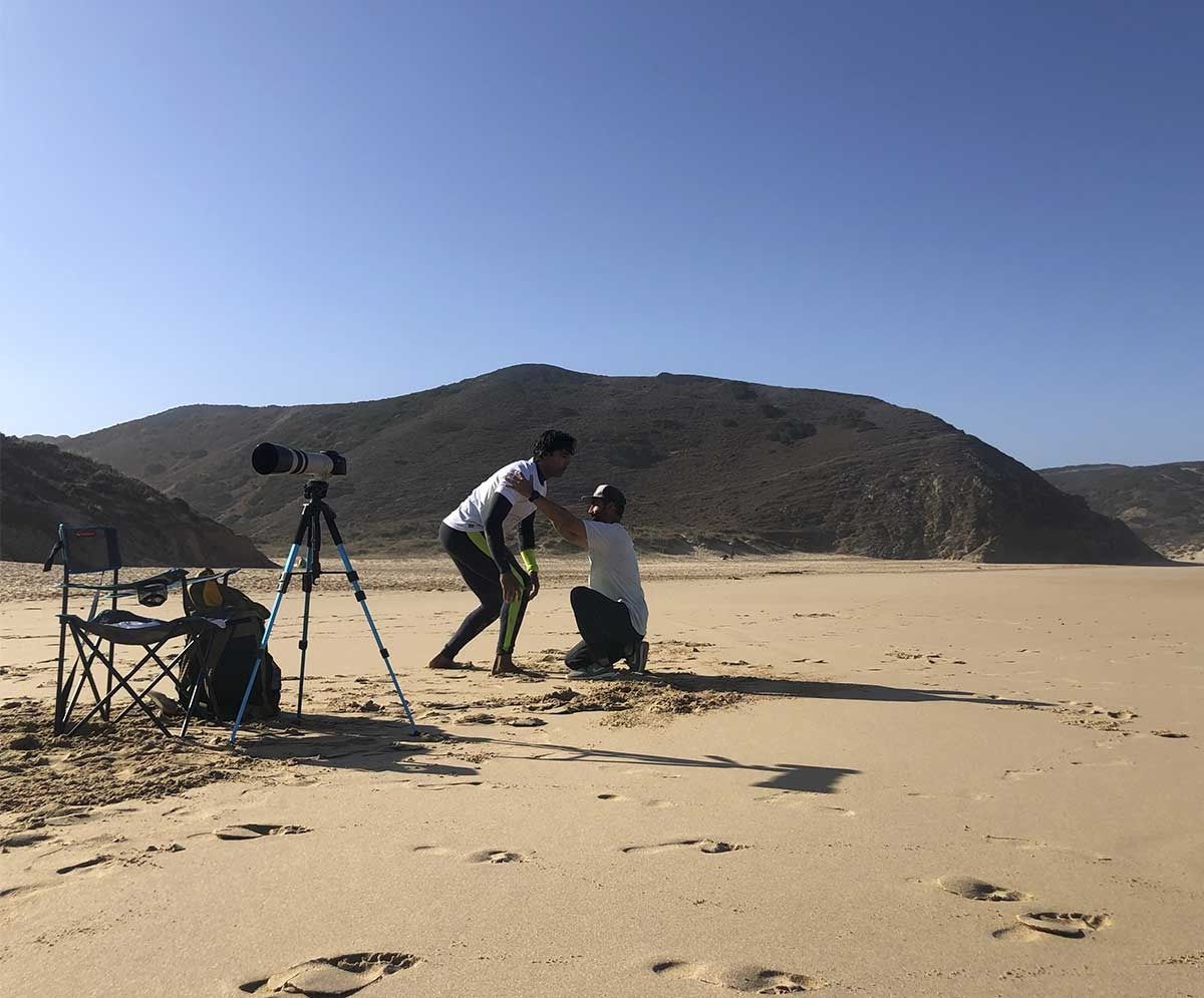 Un grupo de personas está de pie en una playa de arena.