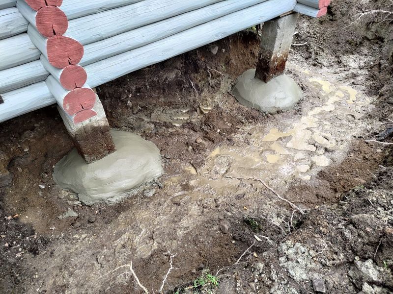 Betoniankkuroiden varassa olevat metalliputket mutaisella rakennustyömaalla