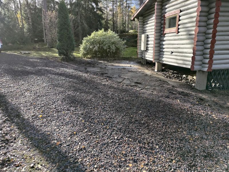 Soratie hirsimökin vieressä, taustalla pieni pensas ja puita.