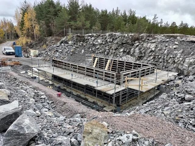 Metallialusta rakenteilla kivisessä louhoksessa, taustalla puita