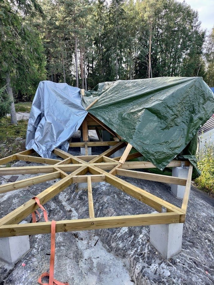 Puinen perustuskehys ja pressulla päällystetty rakenne metsäisellä ulkoalueella