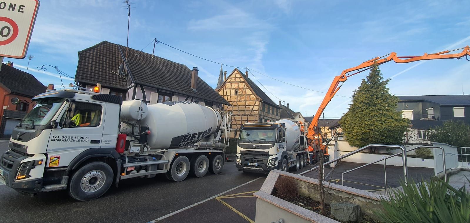 Livraison de béton devant une maison à colombages