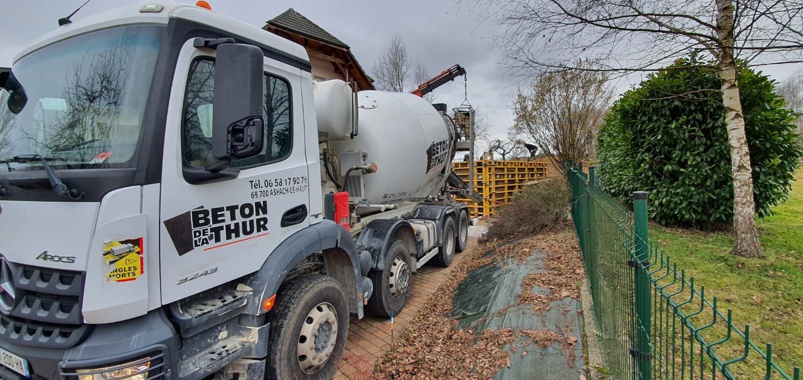 Livraison de béton sur un chantier avec une grue en arrière-plan