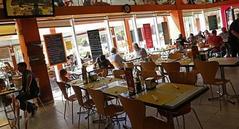 Un grupo de personas están sentadas en mesas en un restaurante.