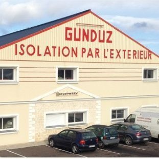 Immeuble avec une enseigne GUNDUZ ISOLATION PAR L’EXTÉRIEUR et des voitures garées devant