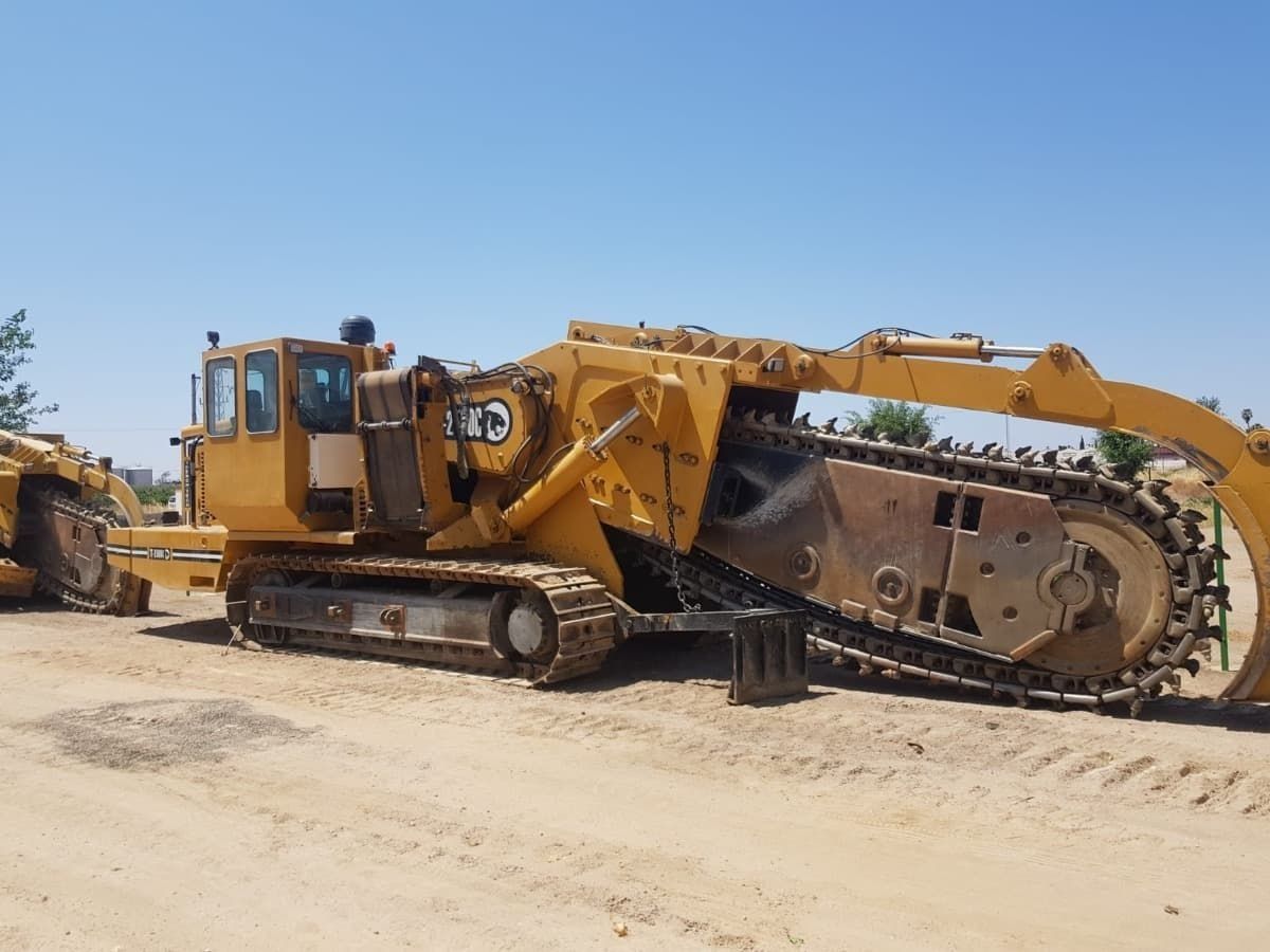 Un gran tractor amarillo está estacionado en la tierra.