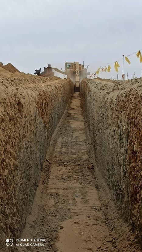 Una excavadora está cavando una zanja en la tierra.