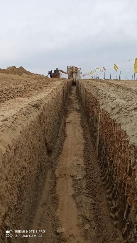 Una excavadora está cavando una zanja en la tierra.