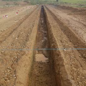 Se está cavando una zanja en la tierra de un campo.