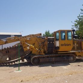 Un tractor amarillo está estacionado en un lote de tierra.
