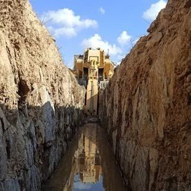 Una excavadora amarilla está cavando una zanja en la tierra.