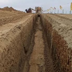 Una excavadora está cavando una zanja en la tierra.