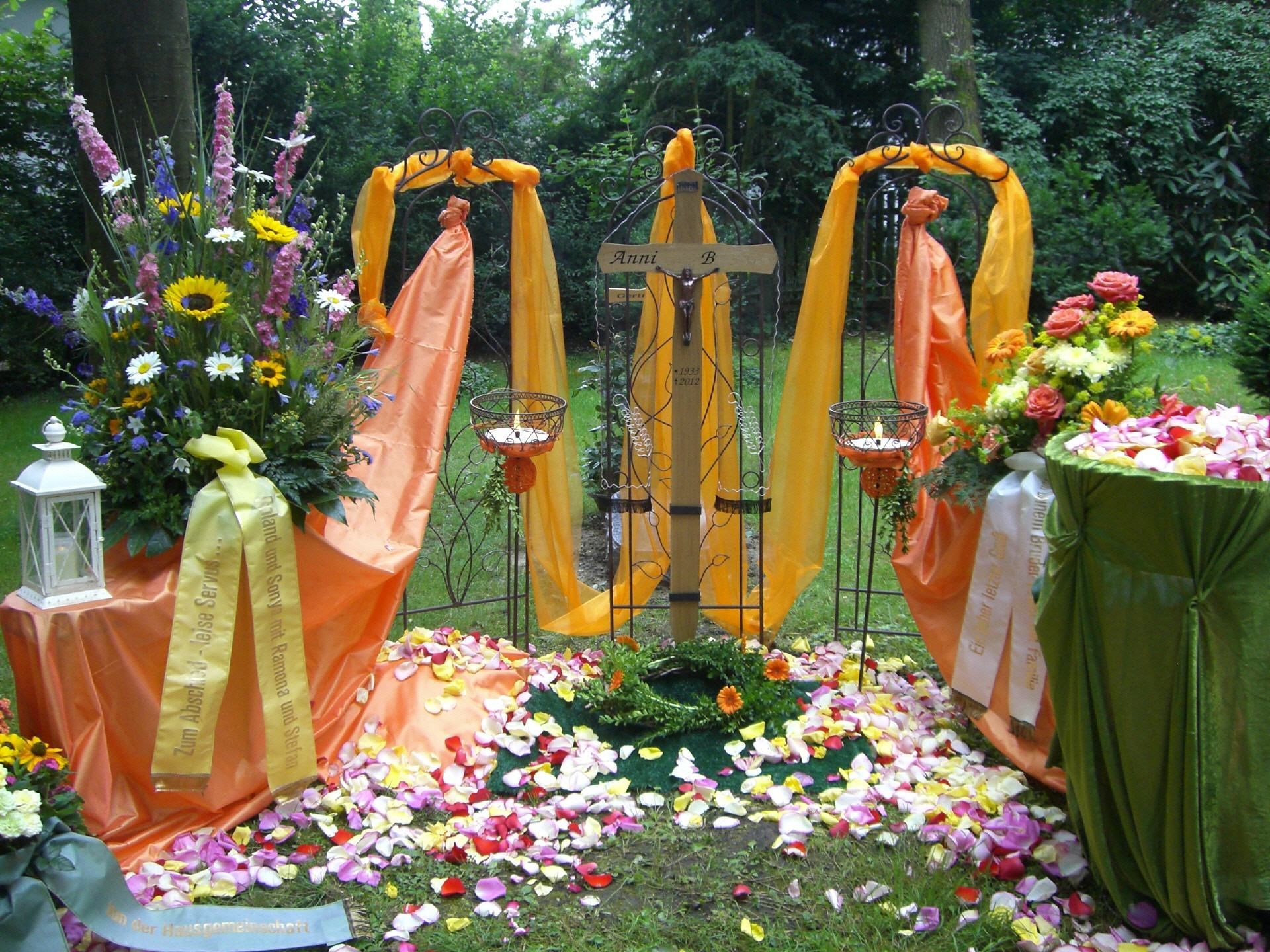 Ein Kreuz steht inmitten eines Gartens, umgeben von Blumen