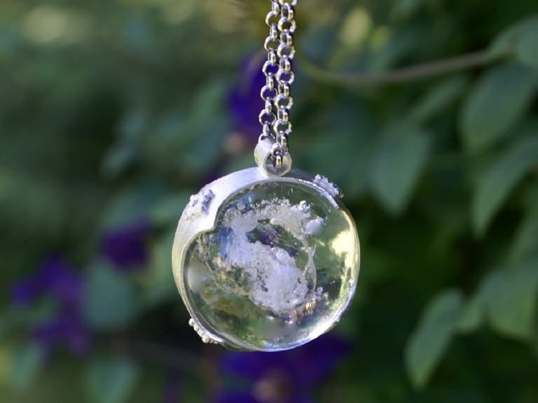 Eine Halskette mit einer klaren Glaskugel darauf