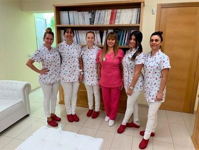 Un grupo de mujeres con uniforme médico posan para una fotografía en una habitación.