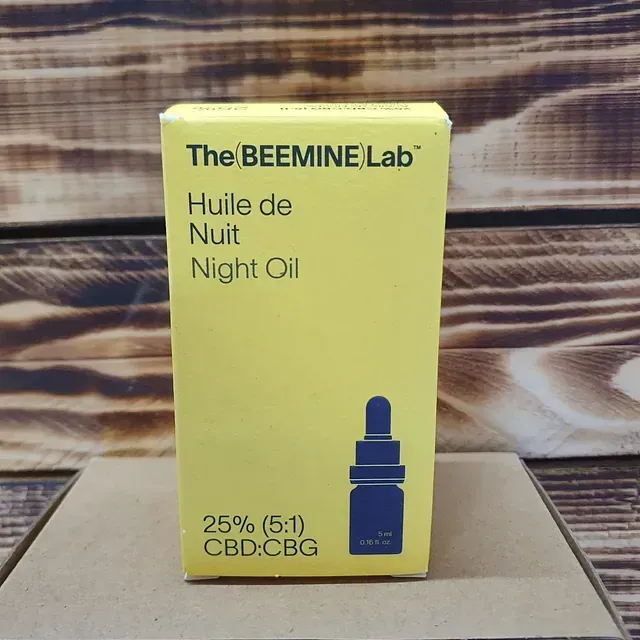 Una caja amarilla del aceite de noche Beemine Lab Huile de Nuit