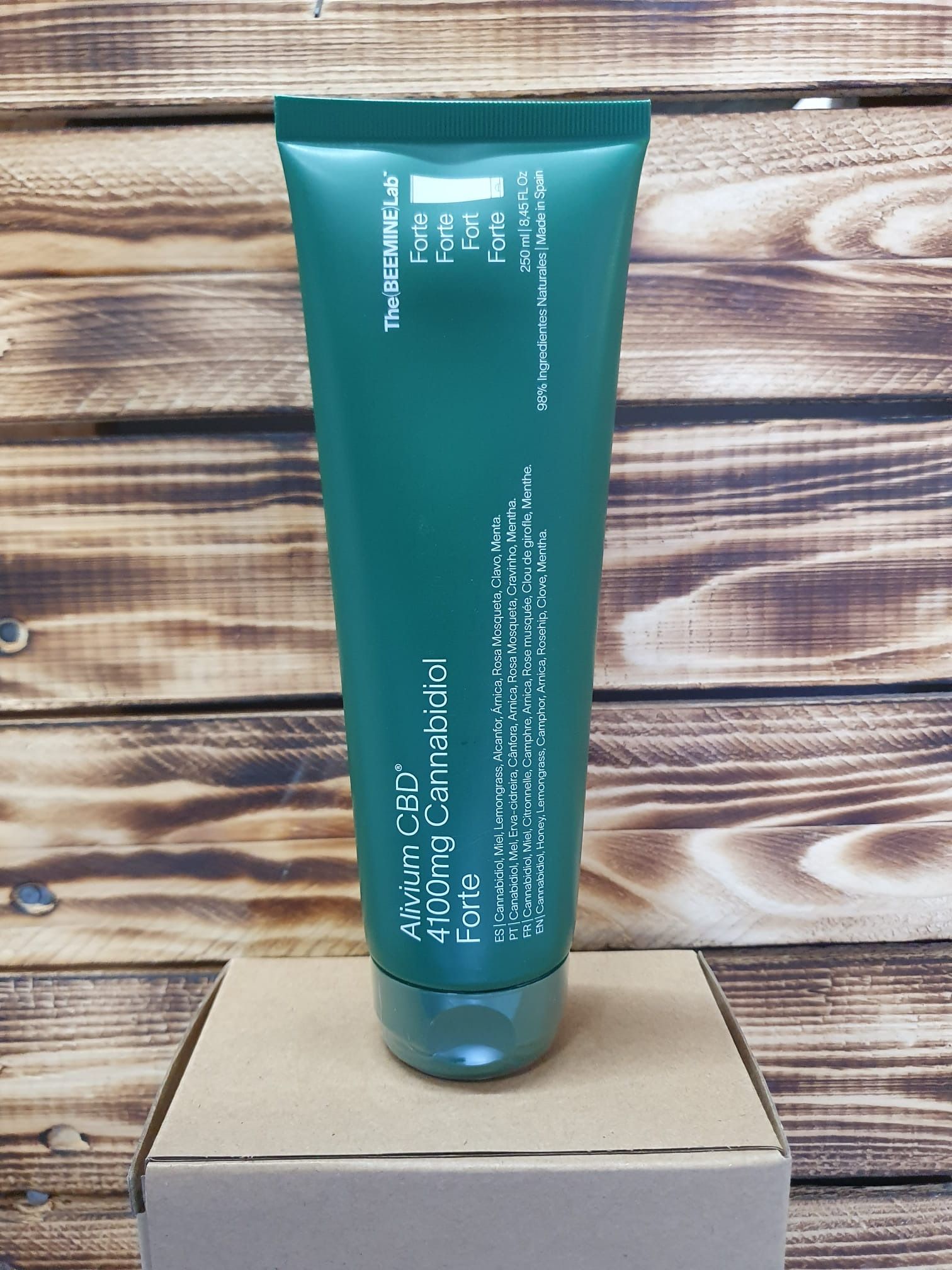 Un tubo verde de loción está encima de una caja de madera.