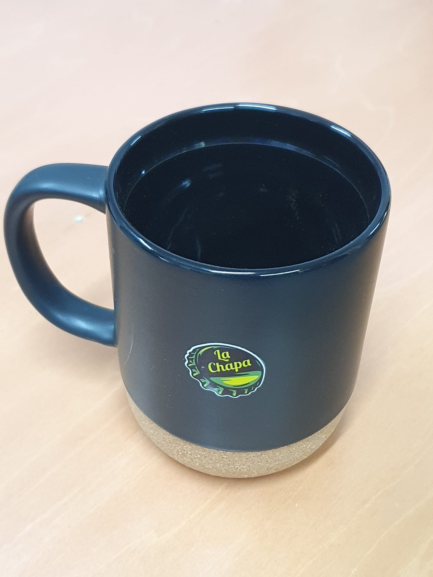 Una taza de café azul con una pegatina amarilla.