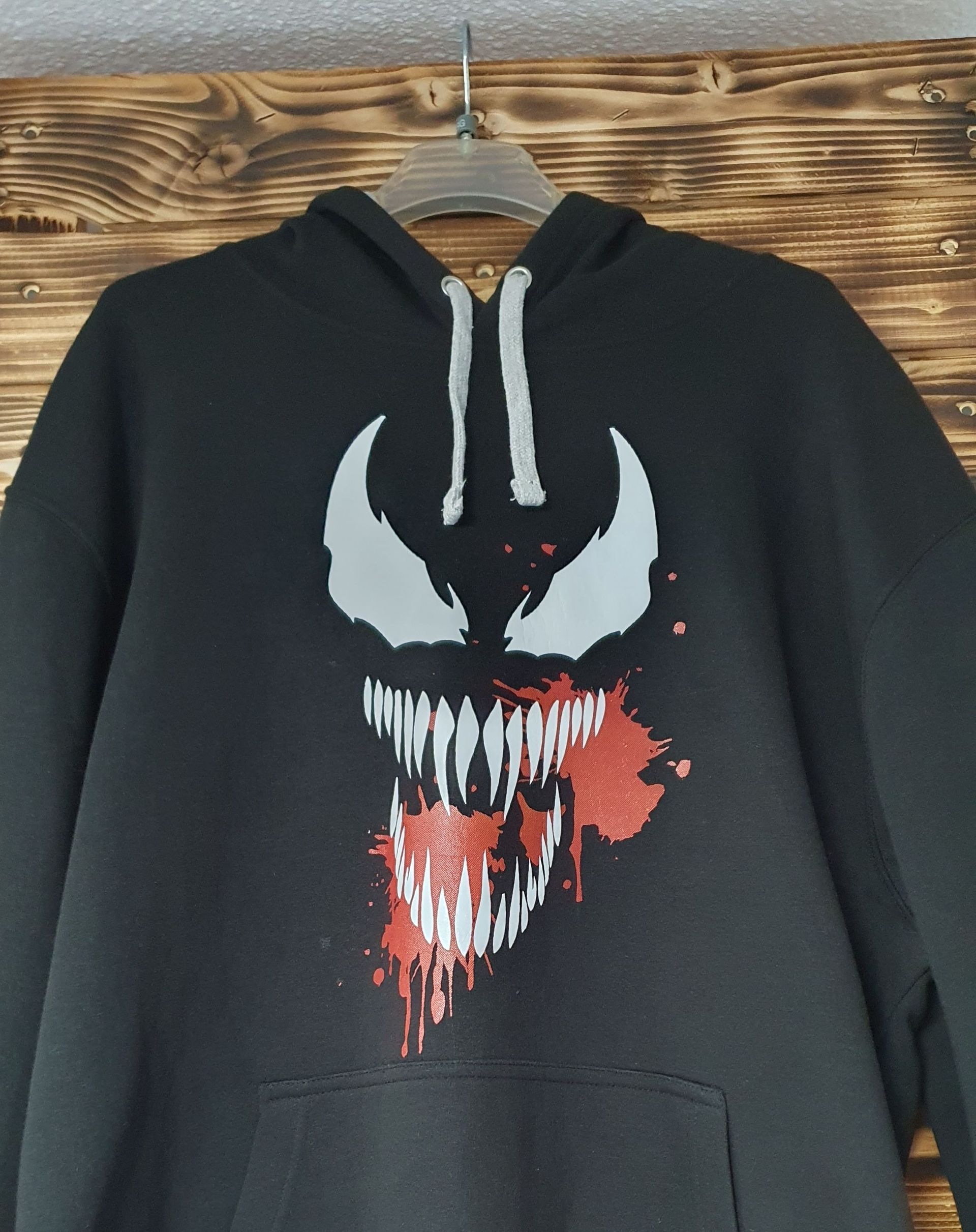 Una sudadera con capucha negra con una cara de veneno.