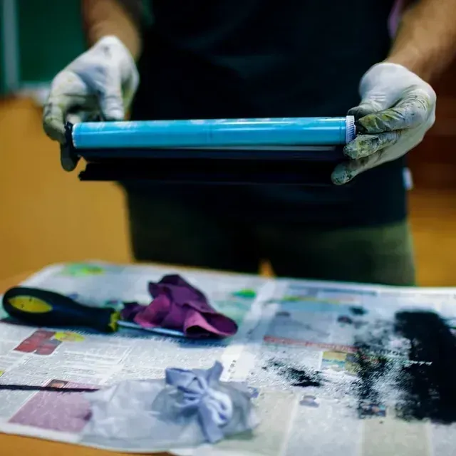 Una persona sosteniendo un cilindro azul en sus manos