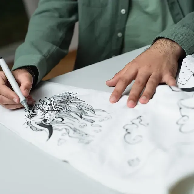 Un hombre está dibujando una imagen con un bolígrafo en un trozo de papel.