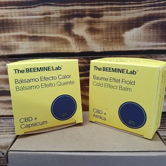 Dos cajas del bálsamo de efecto frío Beemine Lab están sobre una mesa de madera.
