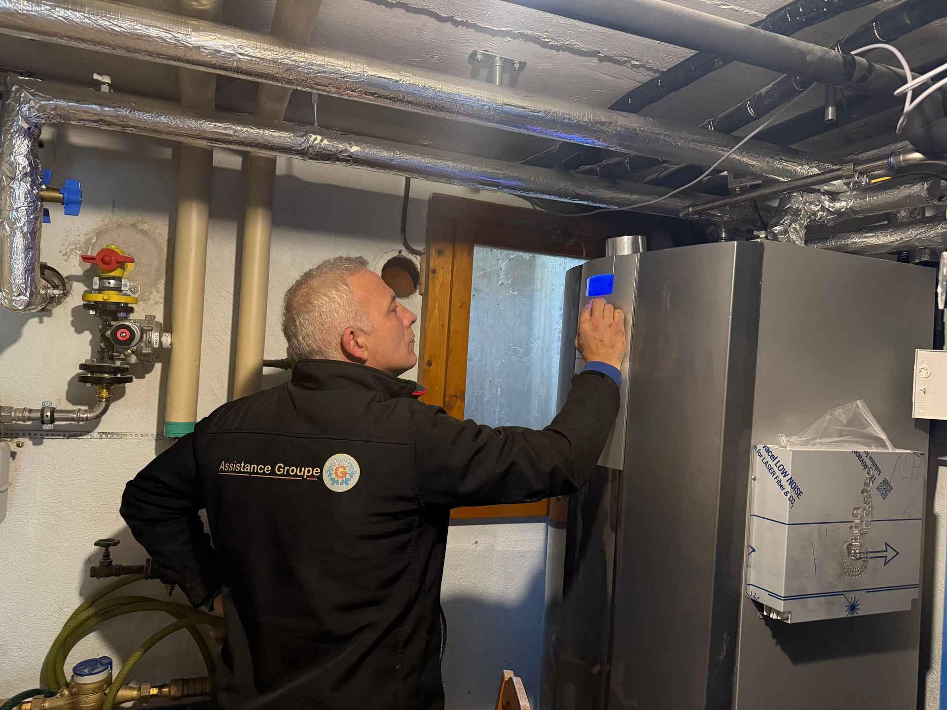 Un plombier, sa boîte à outils et ses outils posés sur le plan de travail.