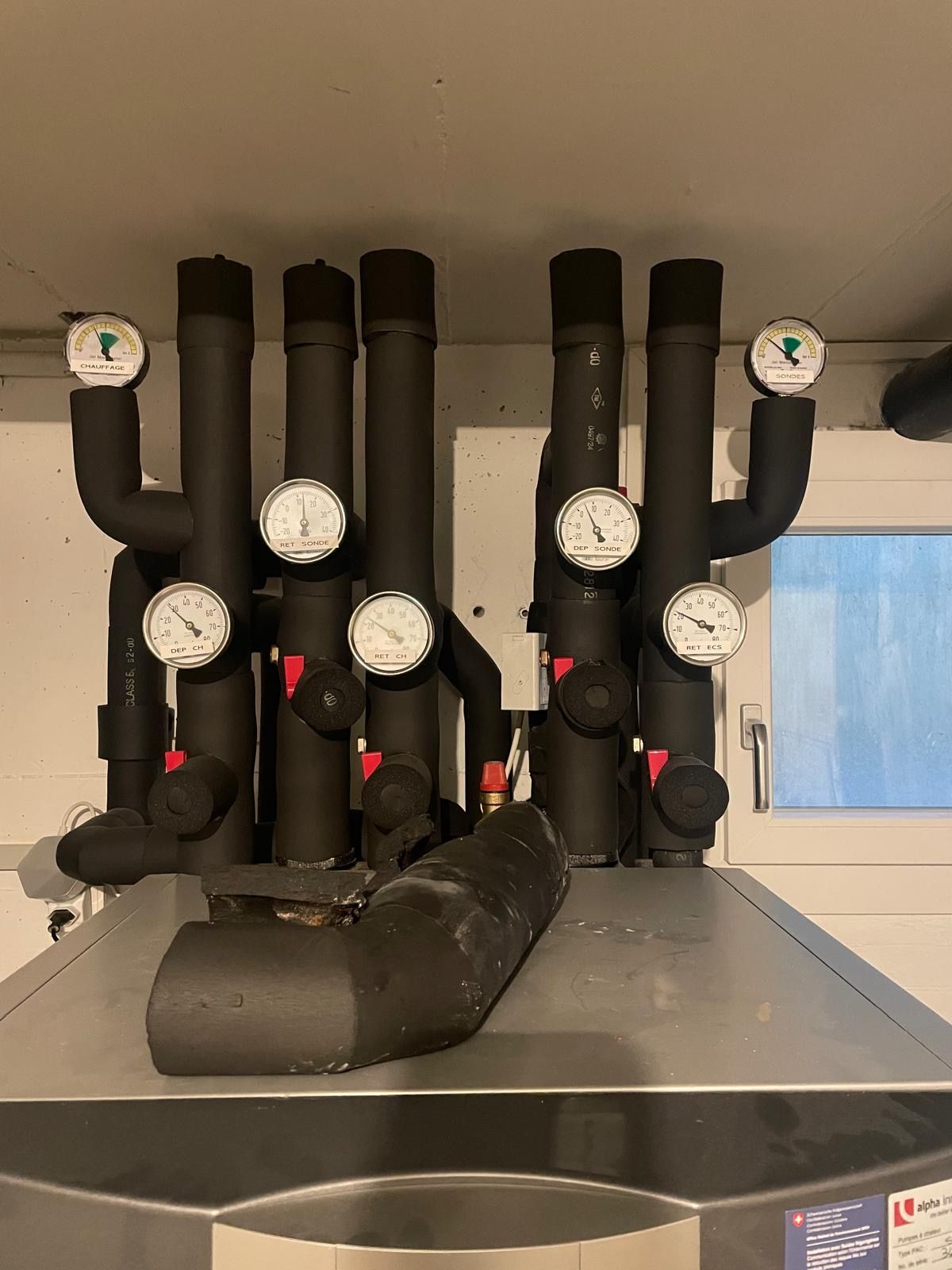 Deux techniciens en CVC examinent une unité de climatisation extérieure, l'un d'eux tenant un bloc-notes.