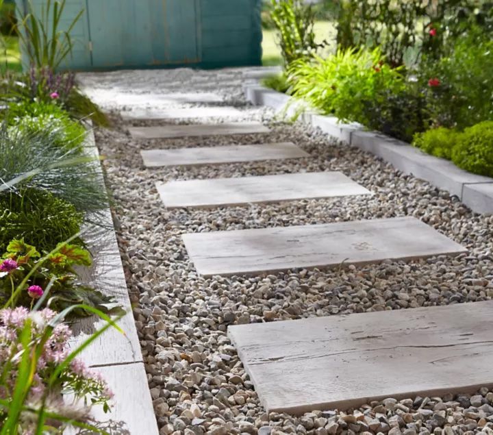 Une allée de jardin en dalles et gravier