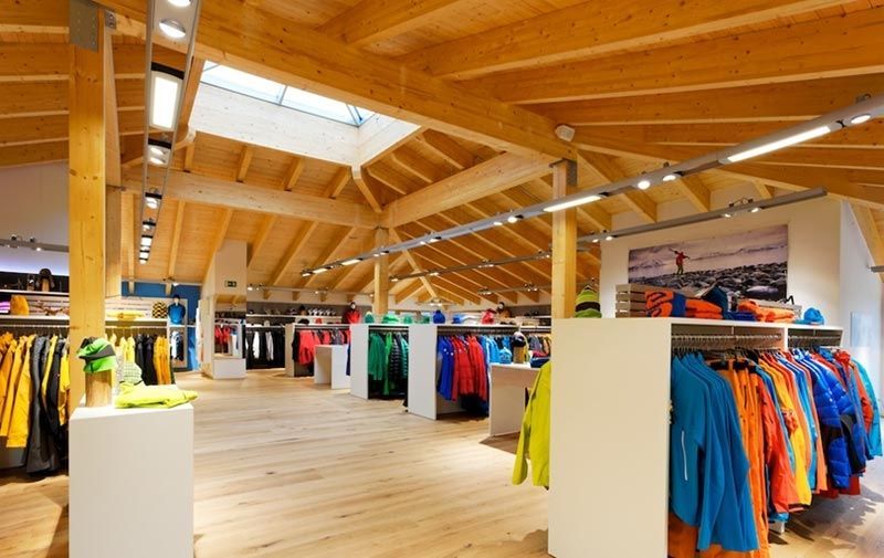 Ein Kleidungsgeschäft mit einem Holzdach und vielen Kleidern